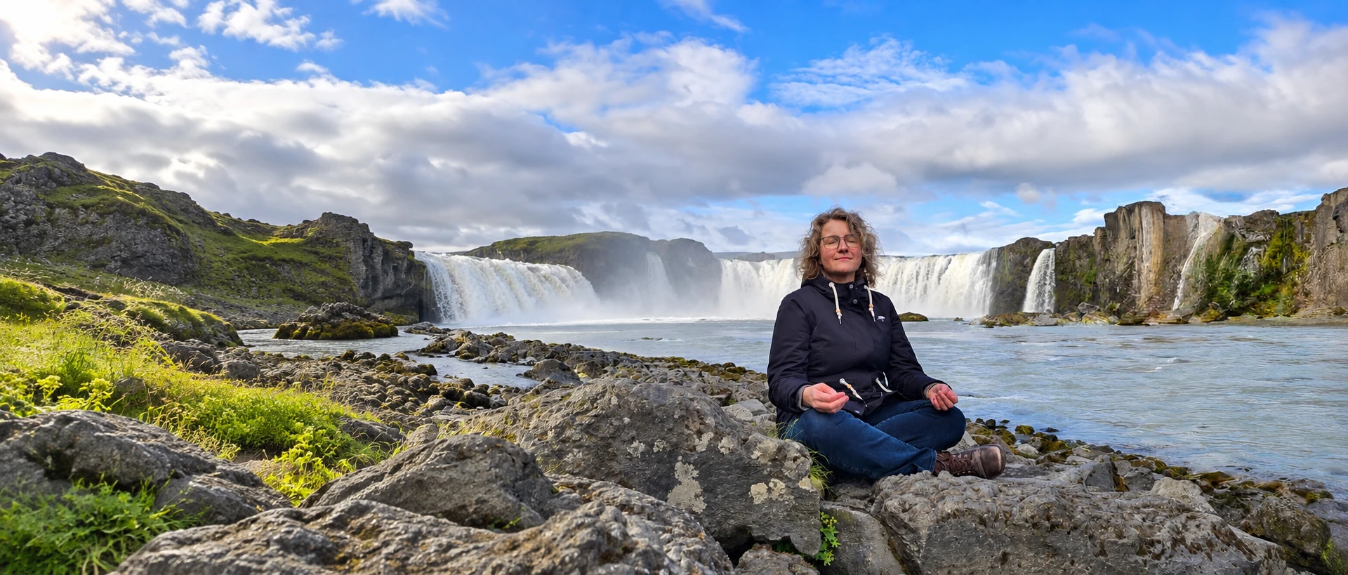 Angelika Düser meditiert vor einem Wasserfall in Island